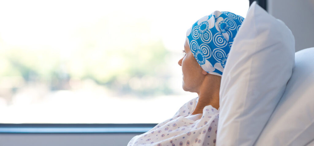Cancer patient looking out of a hospital room window